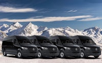 four black mercedes benz sprinter vans parked in front of snowy mountains